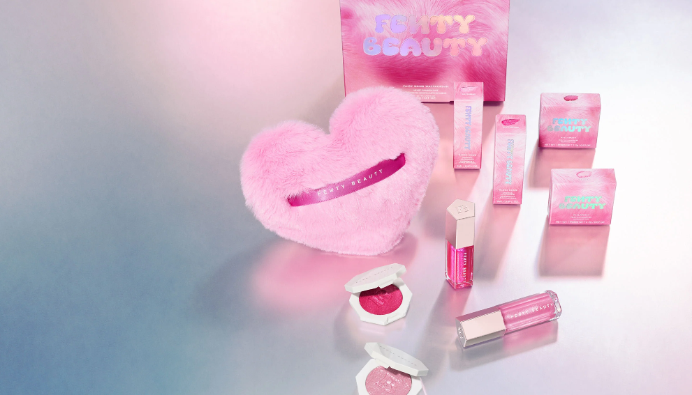 Fenty Beauty lip makeup collection featuring pink Gloss Bomb products arranged on a soft pink background.